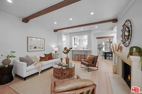 a living room with furniture a fireplace and a chandelier