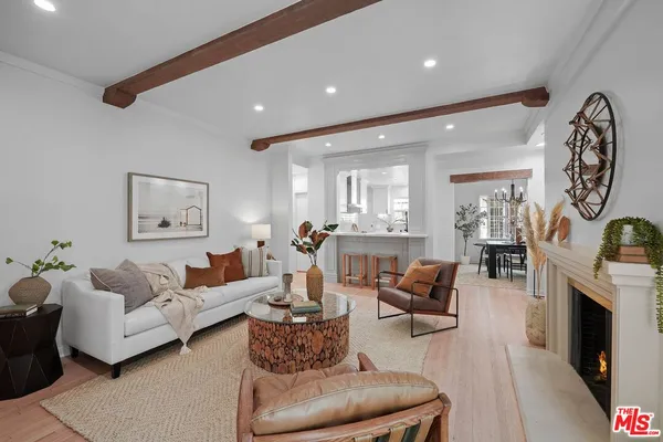 a living room with furniture a fireplace and a chandelier
