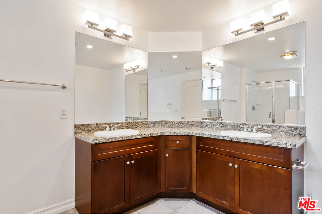 629 Traction Avenue, Unit 507 Los Angeles, CA 90013 - Photo 18 of 52 a bathroom with a granite countertop sink a large mirror and a sink