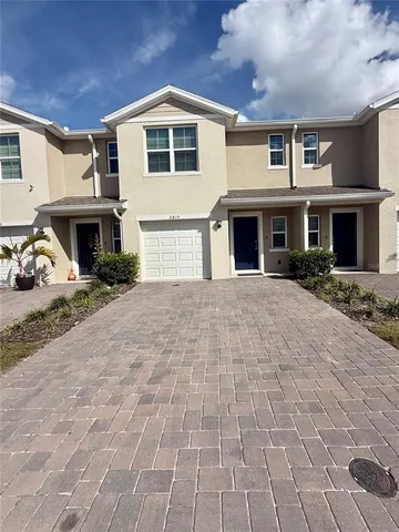 a front view of a house with yard and parking