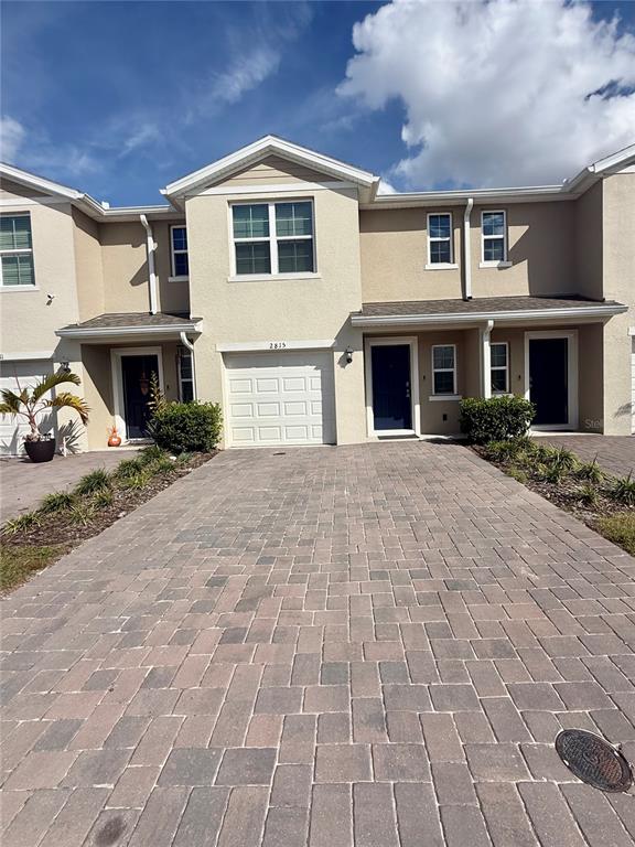 a front view of a house with yard and parking