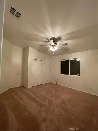 a view of an empty room with a ceiling fan and a window