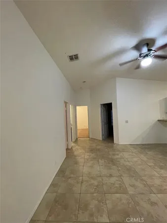 a view of an empty room and a ceiling fan