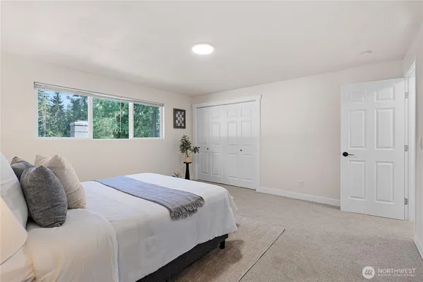 a bedroom with a large bed and a window
