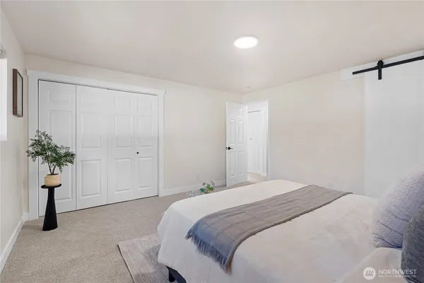 a bedroom with a bed and a potted plant