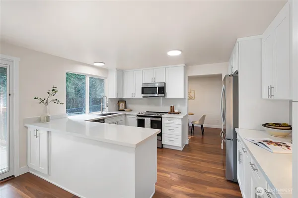 a kitchen with white cabinets and stainless steel appliances