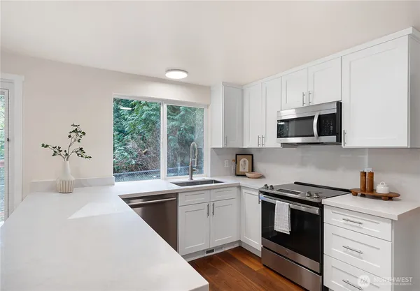a kitchen with a sink stove top oven and cabinets