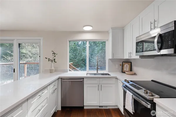 a kitchen with a sink stove top oven and cabinets