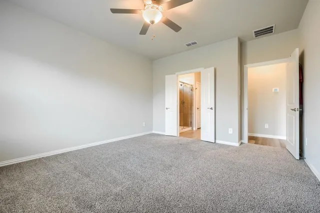 a view of an empty room with a chandelier fan