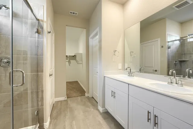 a en suite bathroom with a shower sink and mirror
