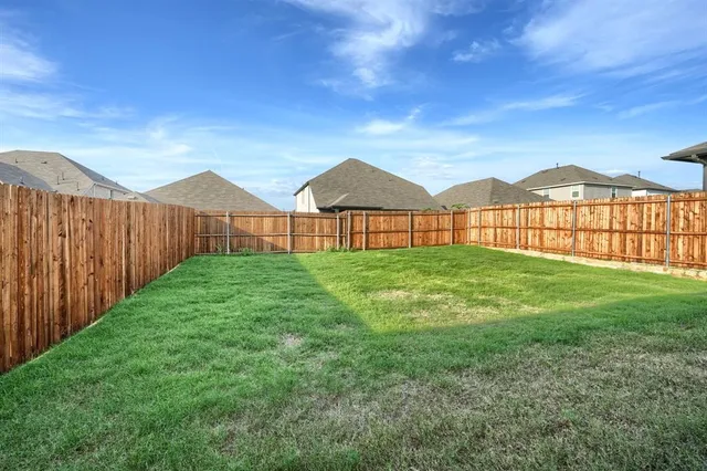 a view of a yard with wooden fence