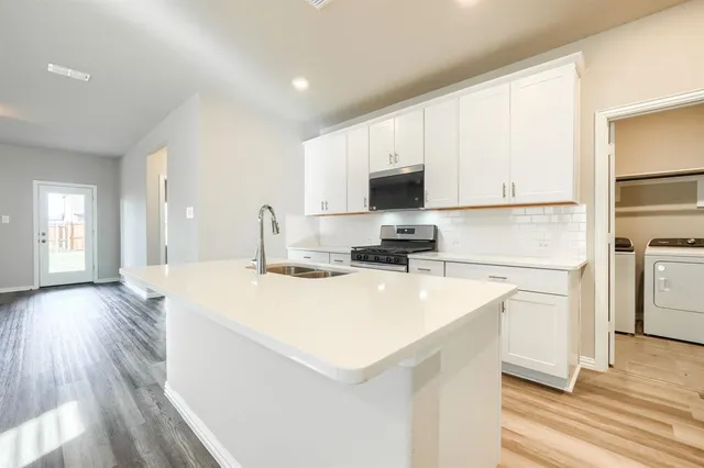 a kitchen with a appliances a sink and a refrigerator