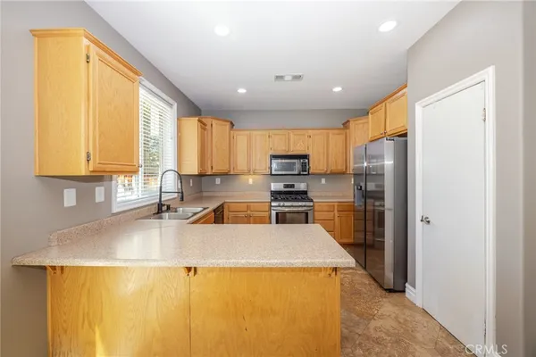 a kitchen with refrigerator a stove a sink and a microwave