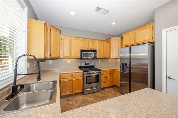 a kitchen with a refrigerator sink and cabinets