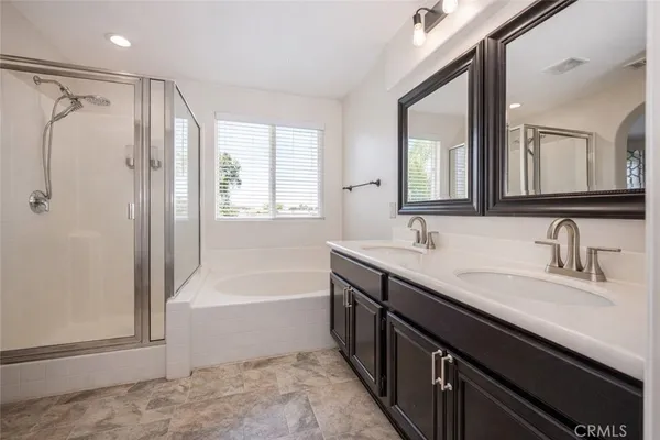 a bathroom with a tub sink and mirror
