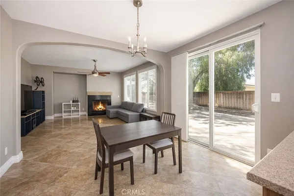 a view of a dining room and livingroom with furniture wooden floor a chandelier