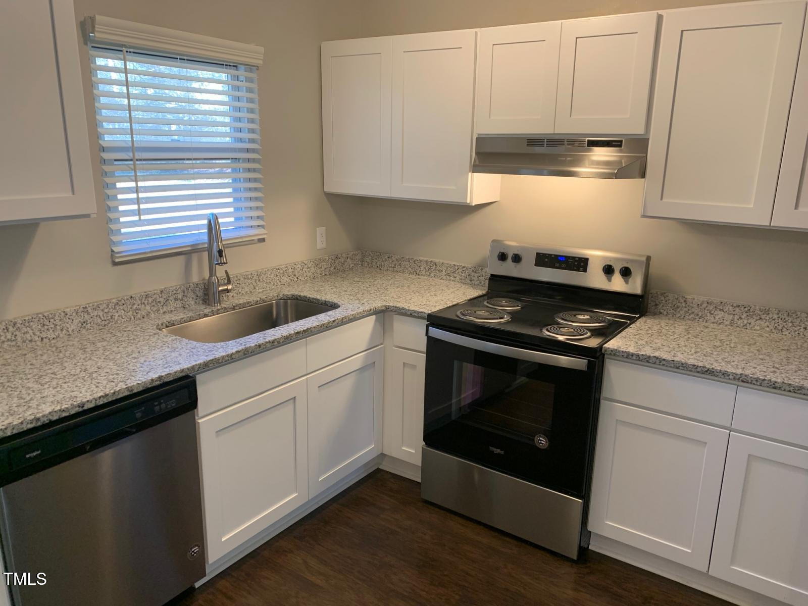 3604 Bowling Drive Raleigh, NC 27606 - Photo 4 of 10 a kitchen with granite countertop white cabinets appliances a sink and a window