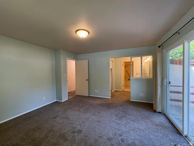 595 Meadowlark Road Orem, UT 84097 - Photo 25 of 87 Carpeted room featuring a ceiling-mounted light fixture, light blue wall paint, white trim, and sliding glass patio doors opening to an exterior deck area