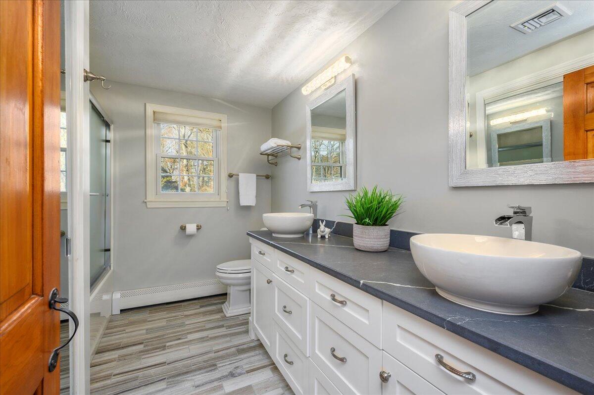 4 Faunce Mountain Road Sandwich, MA 02563 - Photo 17 of 32 a bathroom with a granite countertop sink a large mirror a potted plant and a window