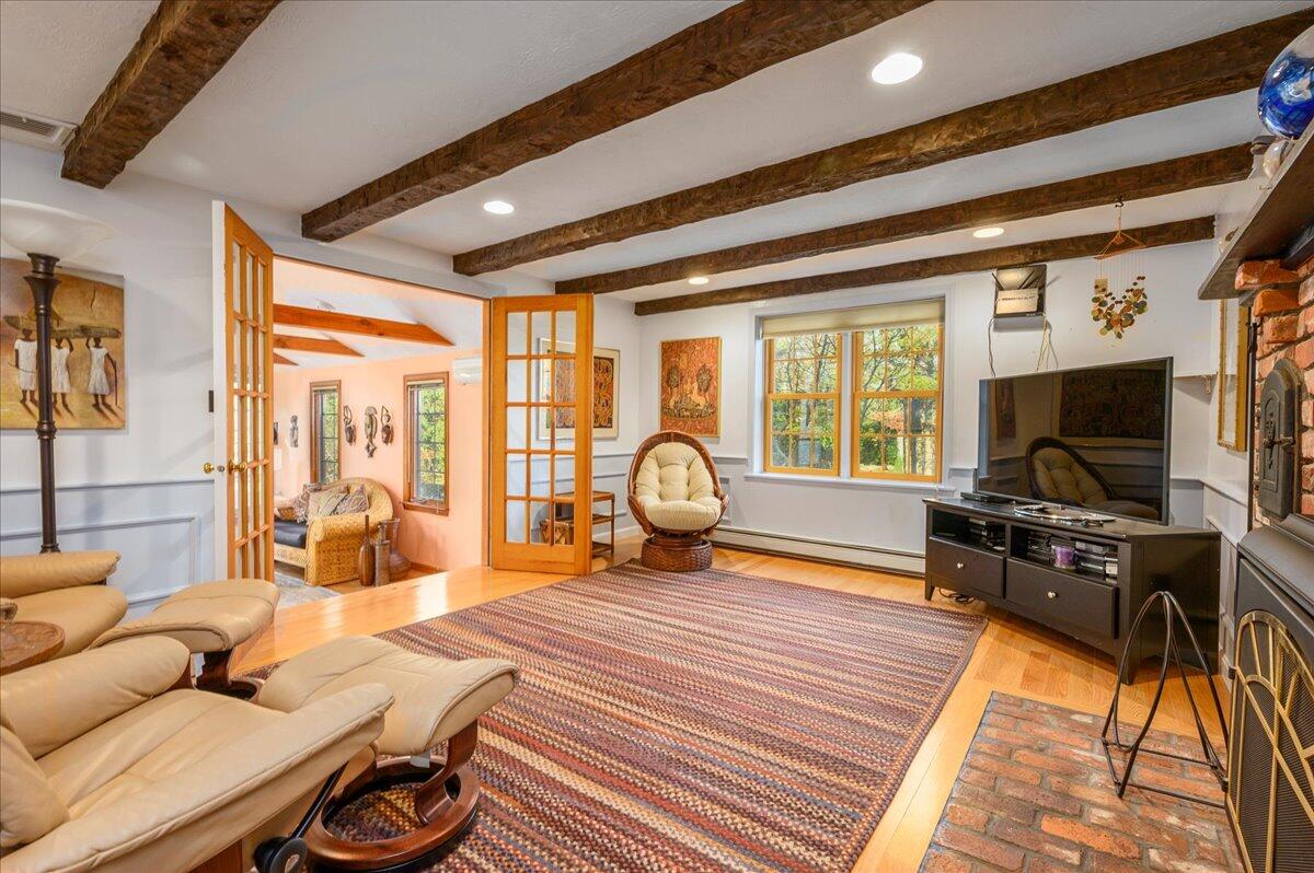 4 Faunce Mountain Road Sandwich, MA 02563 - Photo 10 of 32 a living room with furniture a flat screen tv and a floor to ceiling window