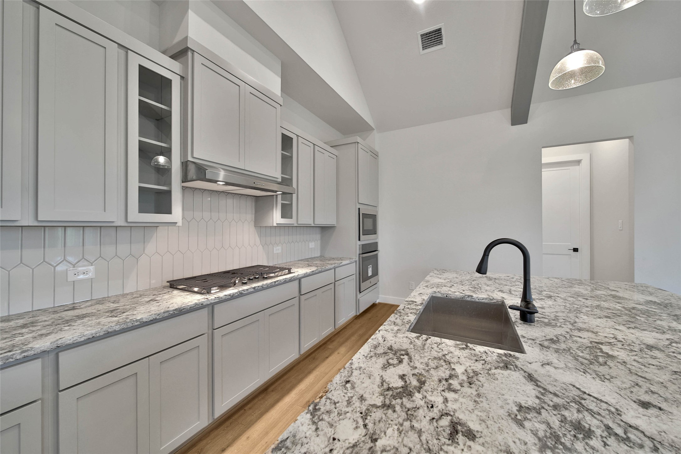 4610 Magnolia Bend Drive Rosharon, TX 77583 - Photo 13 of 48 a kitchen with granite countertop a stove a sink and a white wooden cabinets