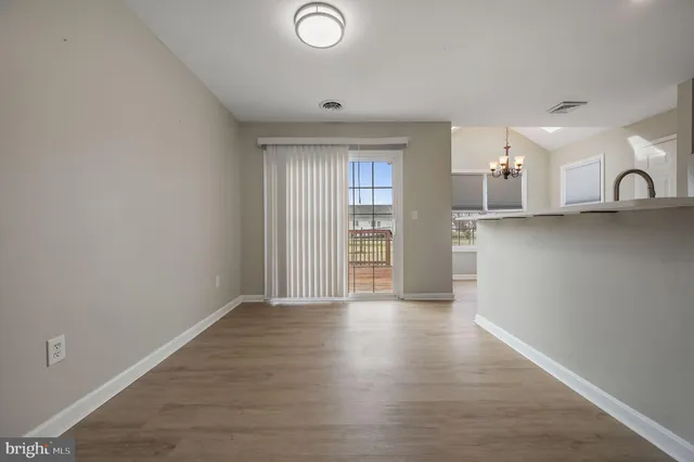 a view of a kitchen with wooden floor and a window