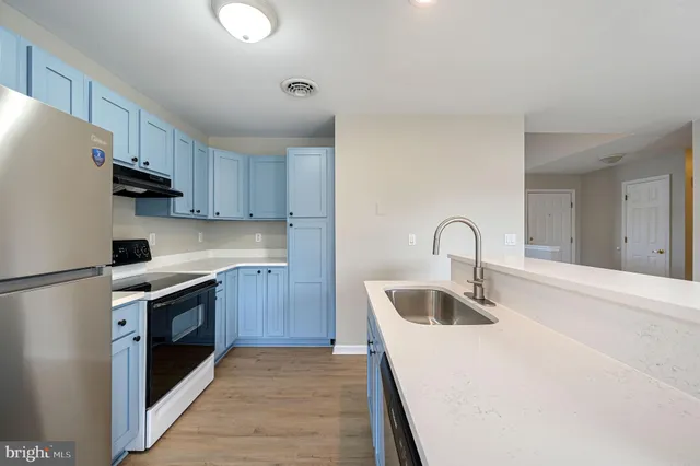 a kitchen with kitchen island a sink stove and refrigerator