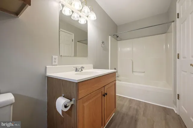 a bathroom with a sink a toilet a mirror and shower