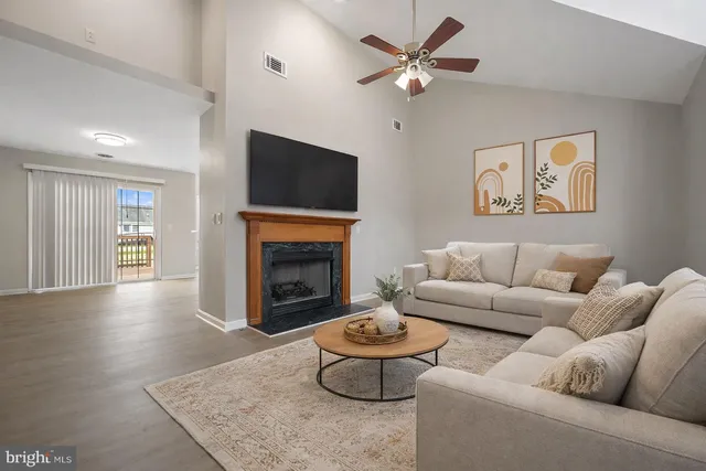 a living room with furniture a fireplace and a flat screen tv