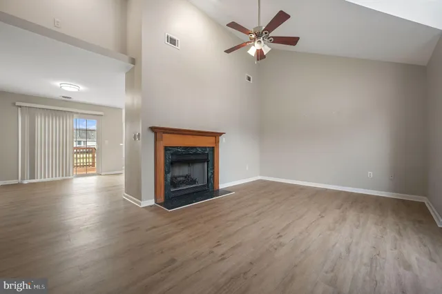 an empty room with windows fireplace and a sink