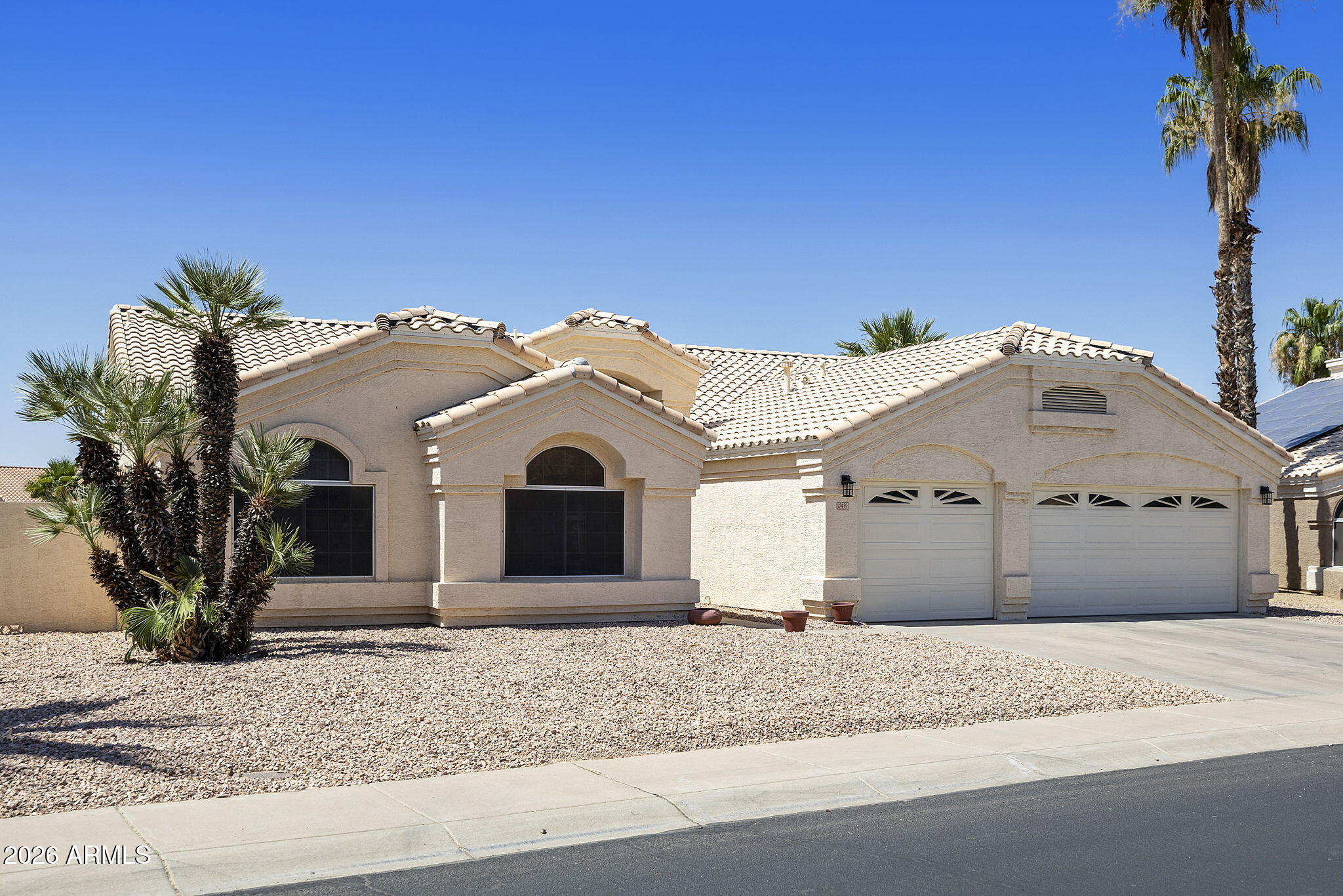 12435 West Monte Vista Road Avondale, AZ 85392 - Photo 6 of 69 a view of a white house with a yard and large tree