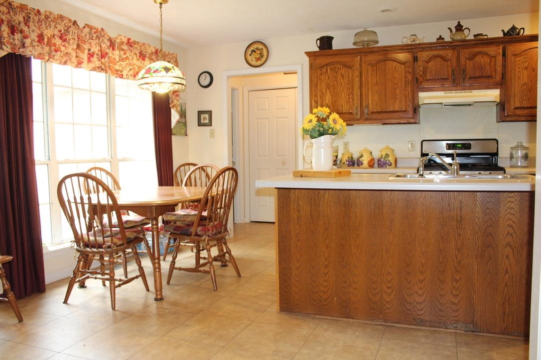 954 New Hope Road Ripley, TN 38063 - Photo 5 of 35 a kitchen with stainless steel appliances granite countertop a dining table chairs and a refrigerator