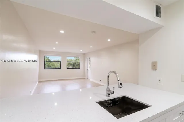 a kitchen with a sink a counter and a dining table