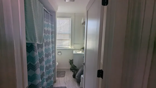 a view of a hallway with furniture and a window