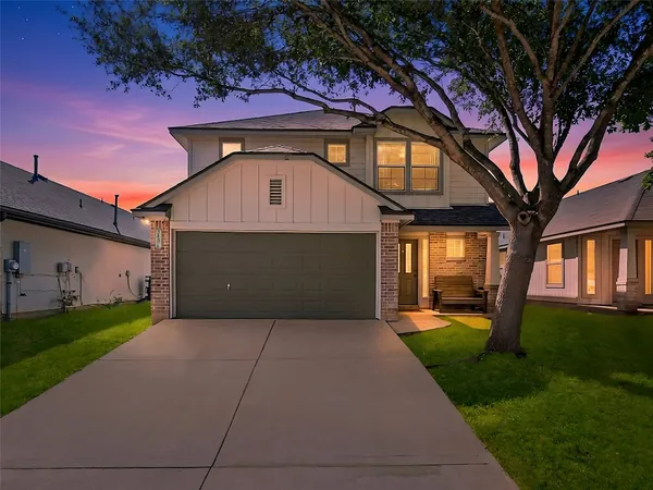 a front view of a house with a yard and garage