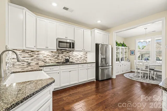a kitchen with a refrigerator stove microwave and sink