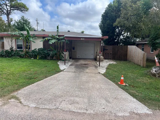 a view of a house with backyard and a tree