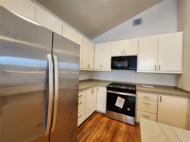 a kitchen with stainless steel appliances granite countertop a refrigerator a stove top oven a sink and dishwasher