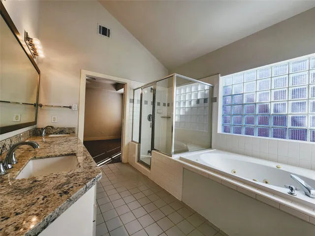 a bathroom with a granite countertop bathtub sink and mirror