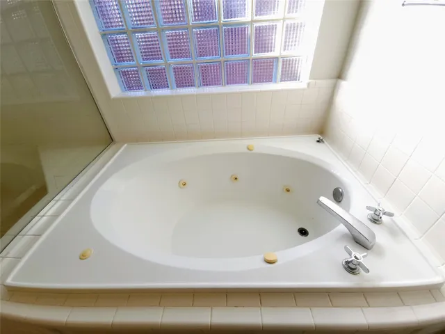a bathroom with a bathtub and a window