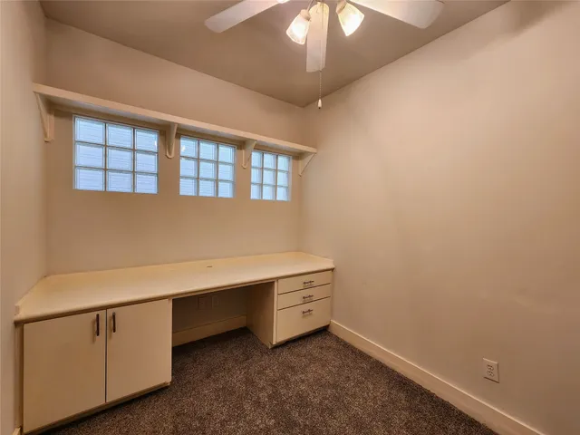 an empty room with closet and a ceiling fan
