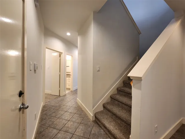 a view of a hallway with wooden floor and staircase