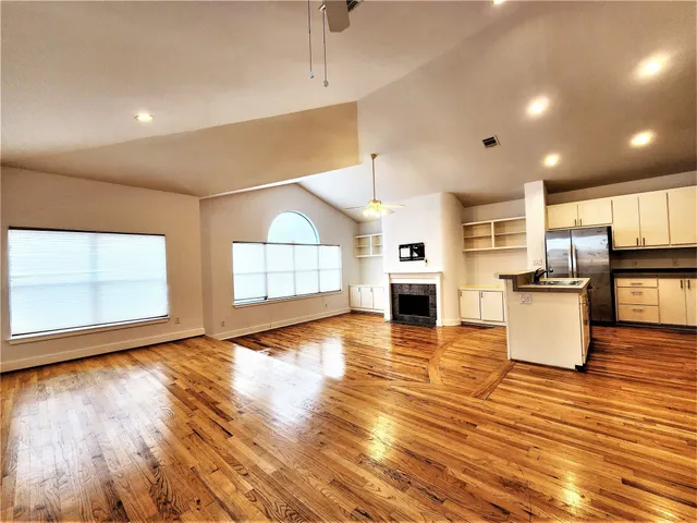 a view of empty room with wooden floor and windows