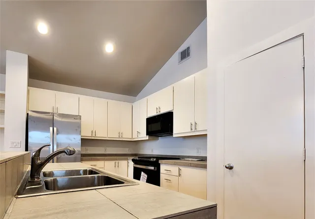 a kitchen that has a sink and a stove top oven