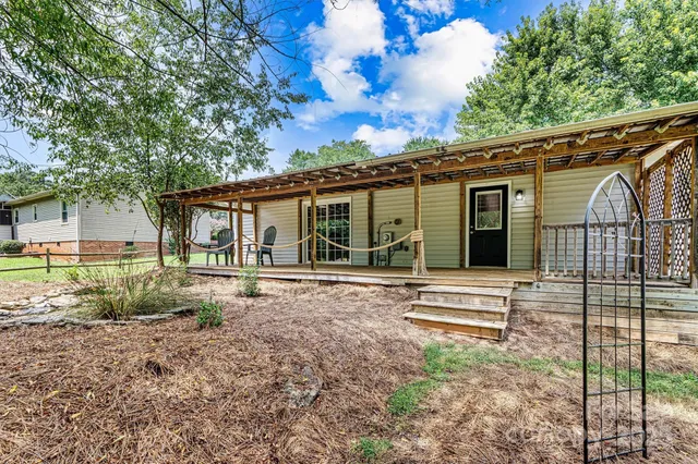 a view of a house with backyard and a tree