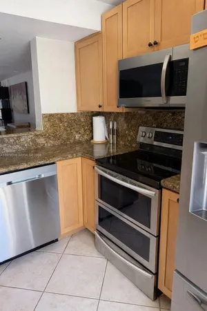 a kitchen with granite countertop a stove and a microwave