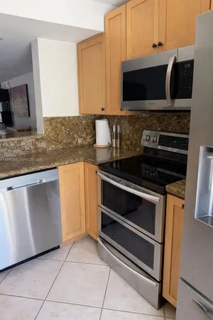 a kitchen with granite countertop a stove and a microwave