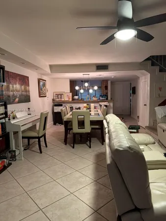a living room with furniture a chandelier and kitchen view