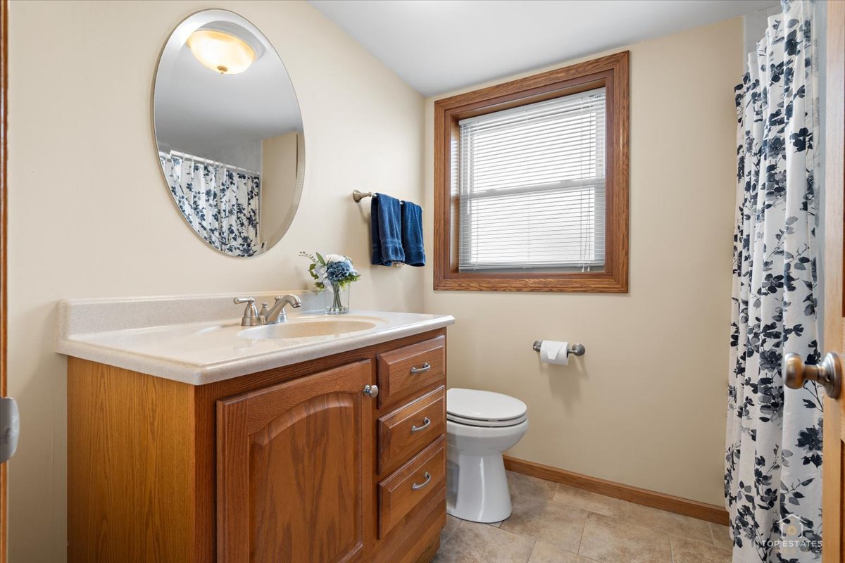 8124 Nottingham Road Tinley Park, IL 60477 - Photo 22 of 33 a bathroom with a toilet sink and mirror