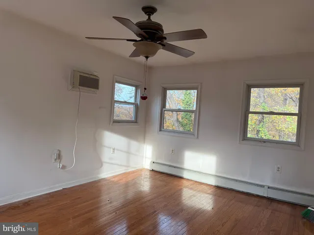 a view of empty room with wooden floor